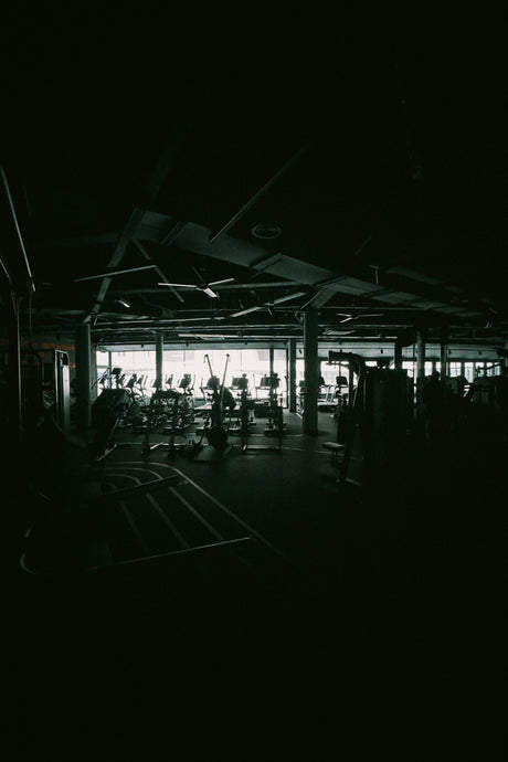 Dark gym interior with exercise equipment visible